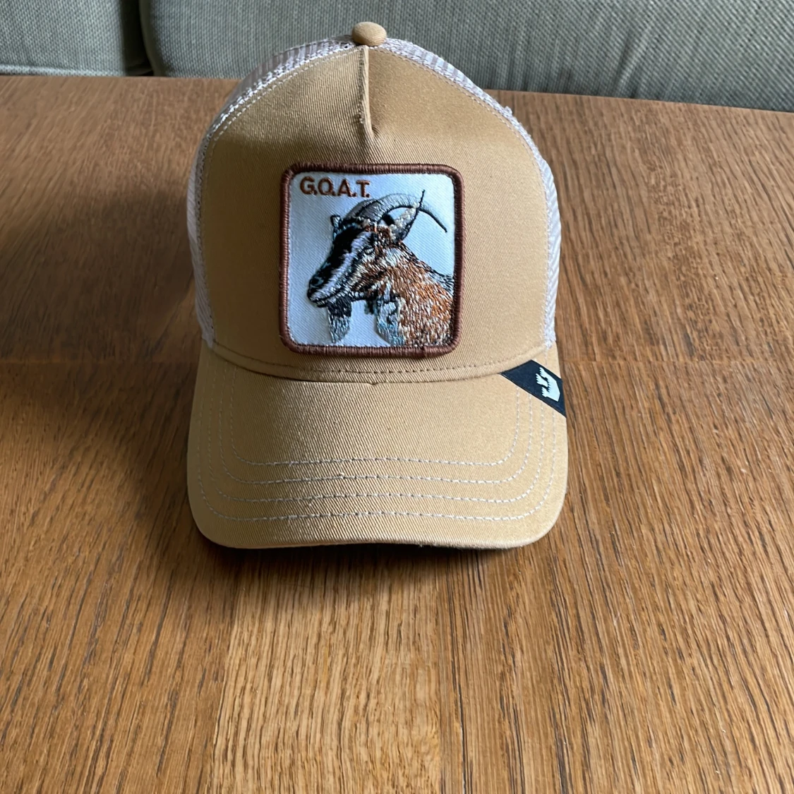 Beige keps med G.O.A.T. motiv