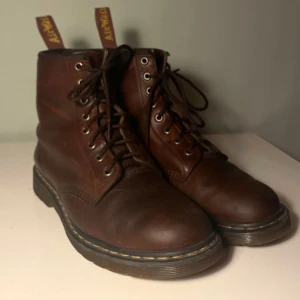 Bruna kängor från Dr. Martens - Bruna vintage Dr. Martens kängor i modellen 1460. Köpta secondhand men använda enbart några få gånger då de är för stora. Väldigt bra skick och är perfekta nu till hösten och vintern.  