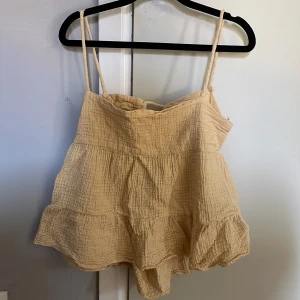 Sommartopp - Fin ljusgul sommartopp med öppen rygg. Sitter så fint på och passar med alla underdelar i princip. Perfekt på sommaren. 