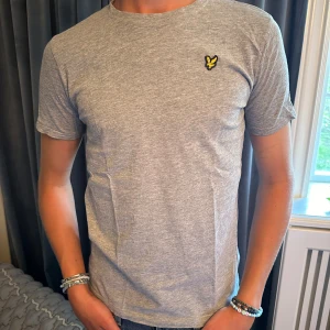 Grå t-shirt från Lyle & Scott - Säljer en snygg grå t-shirt från Lyle & Scott. Den är i nyskick och har en liten broderad logga på bröstet. Storlek S men sitter som M
