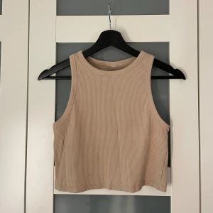 Beiget linne - Beiget lite kroppat linne i mycket fint skick. Lite tjockare material.  Lapp bortklippt, uppskattar storlek till S/M.   Passar snyggt till koftan på bild 2 som jag också säljer! 