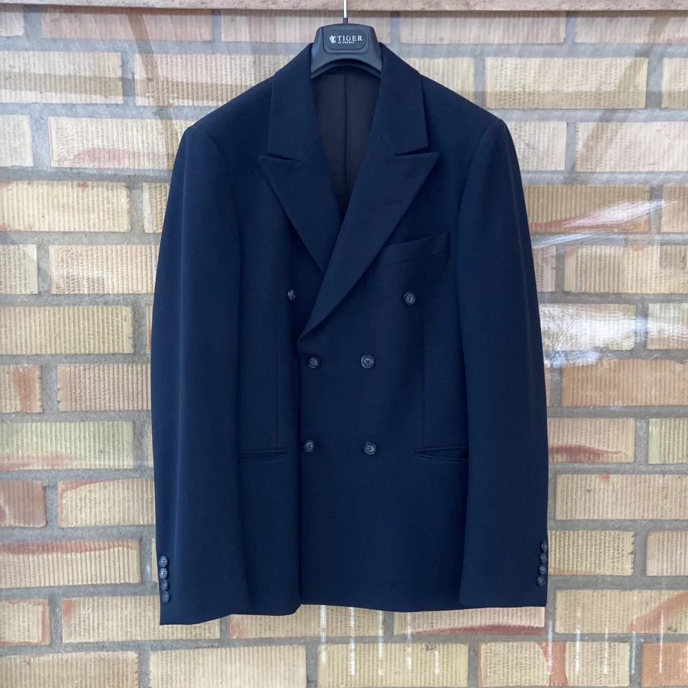Snygg mörkblå kavaj från Tiger of Sweden i stilren design. Dubbelknäppt med klassiska slag och knappar på ärmarna. Perfekt för en elegant look. Inköpt för ungefär 3999kr men använd bara en gång och sedan har den bara samlat damm i garderoben.. Puvut & Bleiserit.