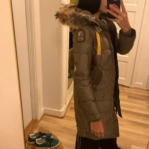 Olivgrön parajumper long bear  - Snygg olivgrön dunjacka från Parajumpers med pälsdetalj på huvan. Storlek xs men skulle kunna passa en s också. 