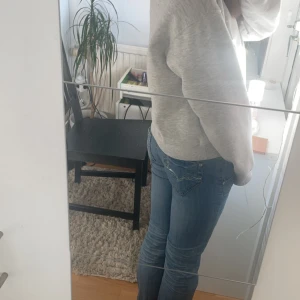 Blå jeans från Denim - Säljer ett par klassiska blå jeans från Denim med snygga detaljer på bakfickorna. Perfekta för en avslappnad stil. Passar till det mesta och är ett måste i garderoben!