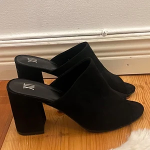 Svarta klackskor från XIT - Snygga svarta klackskor från XIT med öppen tå och bred klack. Perfekta för en stilren look.