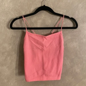 Rosa ribbad linnetopp från House Brand - Säljer en söt rosa ribbad linnetopp från House Brand. Toppen har smala axelband och en enkel design som passar perfekt för varma dagar. Ett lite sportigt material.☺️