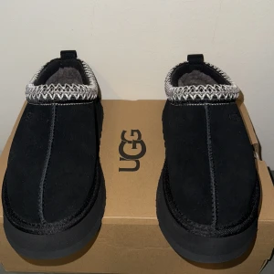 UGG Tofflor - Hej! Säljer ett par svarta UGG W Tazz i storlek 37. Skorna är tillverkade i mocka och har en bekväm passform. Perfekta för att hålla fötterna varma och stiliga. Perfekt julklapp eller liknande. Aldrig använda bara testade! Kvittot/Orderbekräftelse finns om de önskas. För fler frågor kom pm! Mvh Neo💫