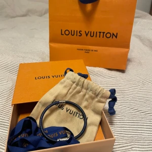 Louis Vuitton split bracelet  - Elegant armband från Louis Vuitton i blått läder med silverfärgade detaljer. Kommer i originalförpackning med påse, låda & kvitto. Perfekt för att ge en lyxig touch till din stil.