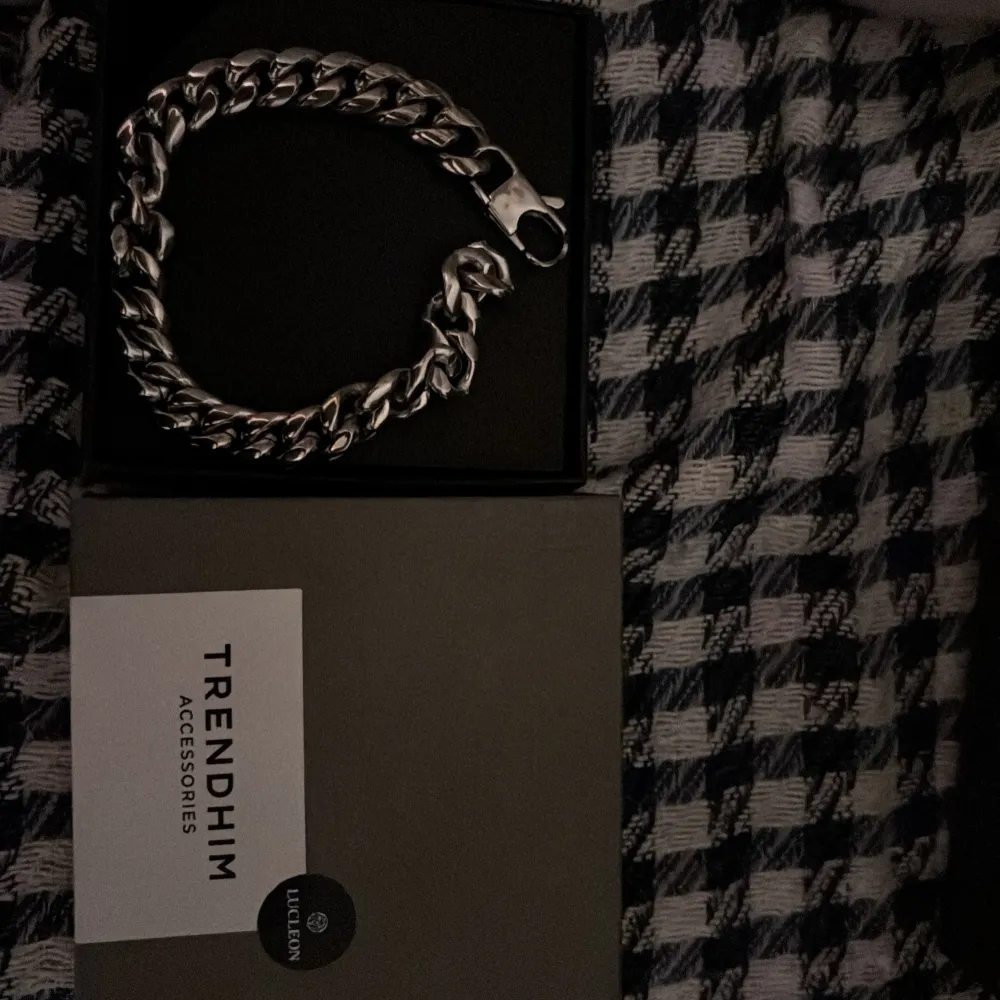 Snyggt och robust silverfärgat armband från Trendhim. Armbandet har en kraftig kedjedesign och ett säkert lås. Perfekt för att ge en stilren touch till din outfit.. Asusteet.