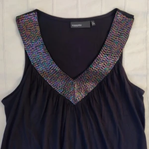 V-ringad y2k topp/tunika med paljetter/glitter/pärlor - storlek XS-M - Mörk (svart eller någon riktigt mörk plommonfärg eller liknande) v-ringad lite längre topp. Resår i nederkanten. Skitsnygg och oanvänd. Storlek M men passar fler storlekar beroende på hur man vill att den ska sitta. 