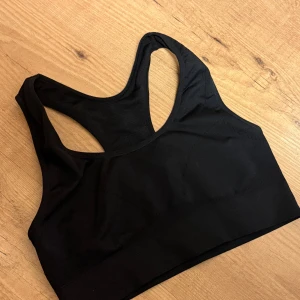 Svart sporttopp från Panos Emporio - Snygg och bekväm svart sporttopp från Panos Emporio. Tillverkad i mjukt och stretchigt material för optimal komfort under träning. Perfekt för gymmet eller yoga.Den sitter som M skulle jag säga. Den är oanvänd 🤍