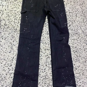 Svarta jeans med färgstänk - Coola svarta jeans med unika vita färgstänk och fickor på sidorna. Perfekta för en avslappnad och trendig look.