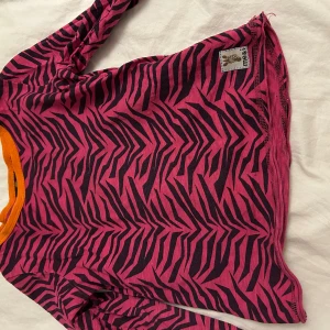 Rosa och svart zebramönstrad tröja från me&i - Säljer en cool rosa och svart zebramönstrad tröja från me&i. Tröjan har långa ärmar och en kontrasterande orange kant vid halsen. Perfekt för att liva upp garderoben! Den kommer tvättas och strykas innan den skickas! ⭐️