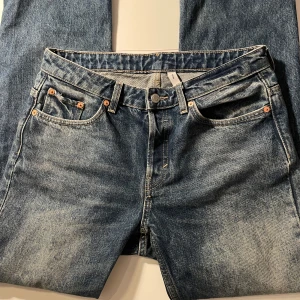 Blå jeans från weekday - Klassiska blå jeans från weekday med fem fickor och knappgylf. De har en traditionell passform och är perfekta för att kombinera med varje outfit. 