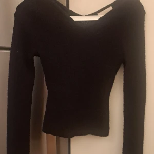 Svart stickad tröja från H&M - Säljer en svart stickad tröja från H&M. Tröjan har en tight passform och långa ärmar med slits perfekt för kyligare dagar. Den är enkel och stilren, vilket gör den lätt att matcha med olika outfits.