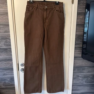 Bruna jeans från Monki - Bruna jeans från Monki i en rak passform. Perfekta för en avslappnad stil med fem fickor och knappgylf.