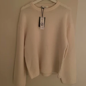 Stickad tröja från Gina Tricot - Stickad tröja med rund halsringning. Tröjan är vit och har oversize fit. Den har ballongärm, normallängd och ribbstickning vid ärmslut och i nederkant.  Tröjan är helt ny, aldrig använd, aldrig ens testad. Jag köpte fel storlek. Prislappen sitter på!  Blandning av akryl, polyester, ull, alpacka och elastan!  Köpt för 399,95kr - Säljer för 300kr