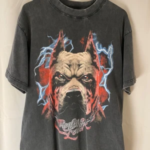 Svart t-shirt med tryck från Culture Kings Rolling Loud  - Cool svart t-shirt från Culture Kings med ett stort tryck av en hund på framsidan och texten 'BEWARE THE NOISE' på baksidan. Perfekt för en edgy look.