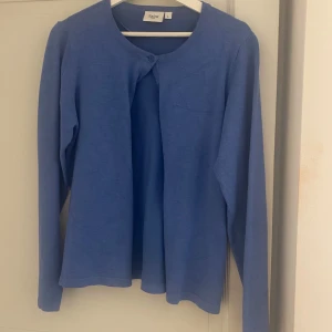 Trendig Blå kofta💞 - Säljer en stilren blå kofta från Saint Tropez. Koftan har långa ärmar och knappar framtill, perfekt för lager-på-lager-stil. Den är mjuk och bekväm, idealisk för både vardag och mer avslappnade tillfällen.