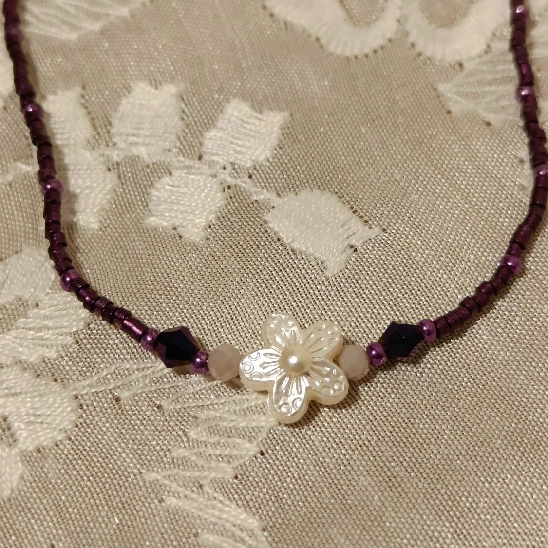 Lila pärlhalsband med blomma - 90