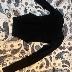 Svart ribbad tröja från Shein - Säljer en stilren svart ribbad tröja från Shein. Tröjan har en tight passform och långa ärmar, perfekt för kyligare dagar. Enkel att matcha med olika outfits.