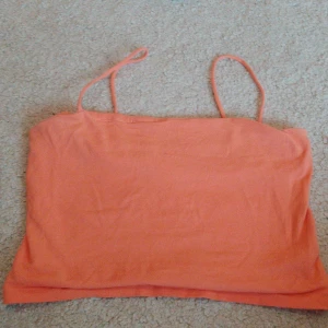 Orange tubtopp från Gina Tricot - Säljer en snygg orange tubtopp från Gina Tricot. Perfekt för sommardagar med smala axelband och en enkel design. Passar utmärkt till både jeans och kjol. 🌞