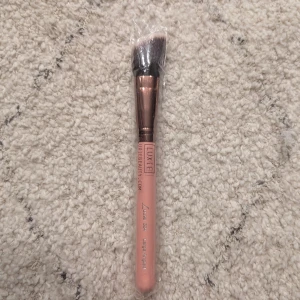 Oanvänd Roséguldfärgad sminkborste från Luxie - Inplastad och oanvänd. Luxie Rose Gold 504 Large Angled Brush. Snygg sminkborste från Luxie med ett rosa handtag och roséguldfärgat fäste. Borsten har täta, mjuka strån som är perfekta för att applicera foundation, bronzer eller rouge. Perfekt julklapp eller födelsedagspresent! ✨ Nypris 235 på Luxies hemsida.