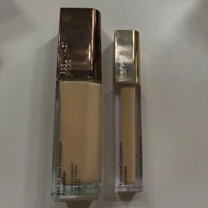 Foundation och concealer från BeautyAct - Säljer en 24H All Wear Complexion Foundation och Luminous Complexion Concealer från BeautyAct. Foundation i nyans 04N och concealer i nyans 06N. Båda produkterna är tillverkade i Italien och kommer i eleganta förpackningar med guldlock. Använts 1gång