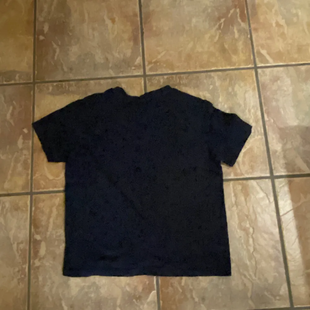 Säljer en klassisk svart t-shirt från Lacoste med den ikoniska krokodilloggan på bröstet. T-shirten har en normal passform och är kortärmad, perfekt för en stilren look. Tröjan har krympt så den motsvarar ungefär storlek 34. T-paidat.