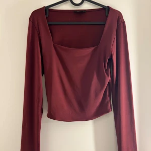 Vinröd långärmad topp - Snygg vinröd topp med långa ärmar och fyrkantig halsringning. Perfekt för höst och vinter. Passar bra till både jeans och kjol.