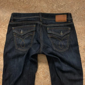 Lågmidjade utsvängda jeans  - Säljer dessa super snygga lågmidjade utsvängda Calvin Klein jeans med coola fickor. Aldrig använt och i bra skick❤️‍🔥 midjemått = 38cm. Innerbenslängden = 81cm