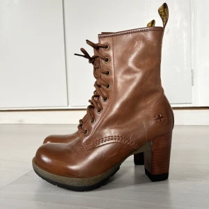 Dr. Martens Stövletter Bruna - Dr. Martens stövletter i brun läder med klack.  Köpta på second hand butik. Aldrig använda av mig, väldigt fint skick. Lite ljusa sträck på sidan av skorna men annars inget större slitage.  Supersnygga.  Hund finns i hemmet.   