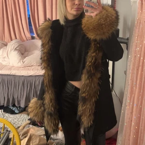 Svart vinterjacka med lyxiga pälsdetaljer (äkta päls) - Säljer en superfin svart vinterjacka från Mao Mao Kong. Den har en lyxig pälsdetalj (äkta päls) runt huvan o armarna. Perfekt för kalla vinterdagar när du vill hålla dig varm och se snygg ut samtidigt. Den är köpt för runt 8k