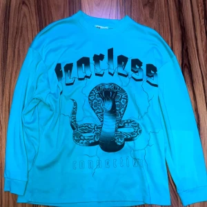 Blå tröja med coolt tryck -  Nopprig vid armarna men annars helt ok skick