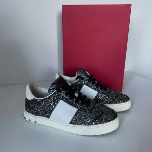 Valentino Flycrew skor  - Säljer ett par valentino Flycrews som är i storlek 36! Skorna är i svart och silver glitter! Alla nitar är kvar! Box medkommer vid köp! Hör gärna av dig om du har frågor!