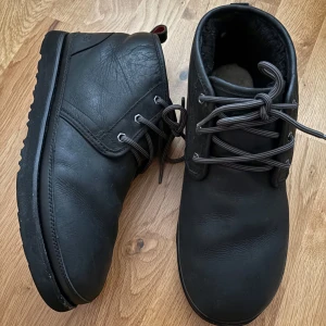 UGG Neumel kängor, vattentäta, strlk 45 - UGG kängor i svart nubuck. Vattentäta. Storlek 45. Bra skick, använda en vinter. Visst slitage längst fram, framför allt på vänster känga, se detaljbilder. Djur o rökfritt hem.