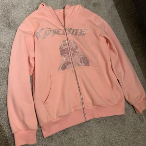 Fullzip hoodie - Säljer denna assnygga rosa ziphoodie då jag inte använder den 🩷. Storlek S, men passar även M. Knappt använd, så väldigt fint skick. Pris går att diskutera vid snabb affär! Nypris va runt 500 😊