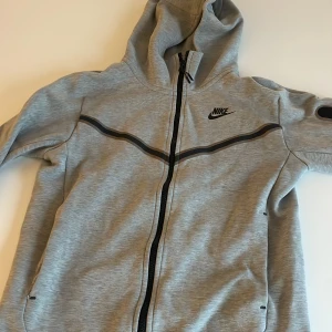 Grå hoodie från Nike - Säljer en grå nike tech i storlek xs. Har andvänt typ 4-5 gånger men har blivit för liten för mig? Skriv vid frågor eller köp 😀