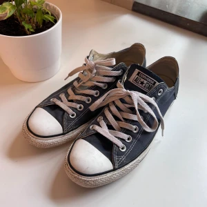 Converse low - Marinblå Converse i använt skick. Köpta i andra hand, tidigare ägaren sa att de är lagade hos en skomakare (se andra bilden).  Skorna är lite smutsiga, går att få bort. Normal i storlek