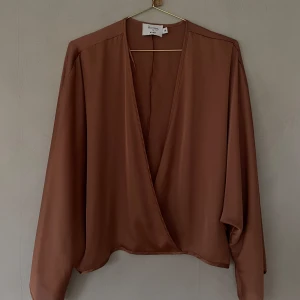 Rostbrun silkesblus  - Rostbrun blus med lång ringning och arformade armar. Glansigare irl. Aldrig använd Inga bilder med den på 💕