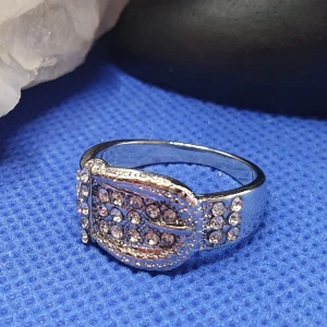 Ring föreställer ett Skärp / Bälte st 19 - Ring i silver med strass, föreställer ett skärp/bälte st 19. ✨️✨️✨️Titta igenom alla mina upplagda och köp fler saker i bundle för att spara på frakten och få allt du köpt i ett och samma paket✨️✨️✨️