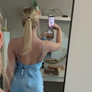 Ljusblå sidenklänning med slits / balklänning - Helt oanvänd alklänning med lappen kvar, i storlek 40/M/L. Elegant ljusblå klänning i siden med smala axelband och en stilren slits på sidan. Perfekt för en somrig look med sin mjuka och glansiga finish.💓