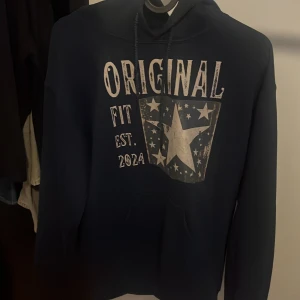 Mörkblå hoodie med stjärntryck - Säljer denna stilrena mörkblåa hoodien från SCNDI i storlek S. Använd ett fåtal gånger och säljs då den inte passar. Hör av er vid funderingar. 