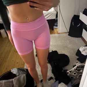 Rosa träningsshorts - Säljer ett par rosa träningstights i en tight passform med scrunch i rumpan. sitter som en xs