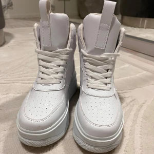 Sneakers - Vita high top sneakers med platåsula. Använda 1-2 gånger. Inga skador eller märken. Nyskick