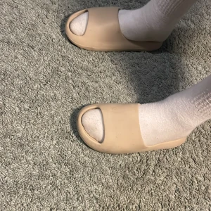 Beige sandaler - Säljer ett par bekväma beige sandaler med öppen tå och ribbad sula. Perfekta för en avslappnad stil och enkla att matcha med olika outfits.