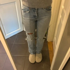 Ljusa jeans med slitningar - Snygga ljusa jeans med slitningar på knäna. De har en klassisk femficksdesign och en rak passform. Perfekta för en avslappnad stil. Mid waist passform