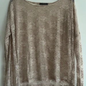 Beige spetsblus från frk. - Säljer en elegant beige spetsblus från frk. med långärmad design. Perfekt för att lägga till en touch av stil till din garderob. Blusen har ett vackert blommönster och är tillverkad i ett lätt och luftigt material.