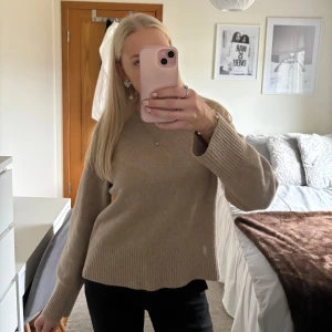 Beige stickad tröja - Såå mysig beige stickad tröja med långa ärmar och ribbade detaljer vid ärmslut och nederkant. 