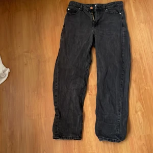 Svarta jeansbyxor - Snygga svarta jeansbyxor med klassisk femficksdesign och knappgylf. Perfekta för en avslappnad stil med en rak passform som ger en tidlös look.